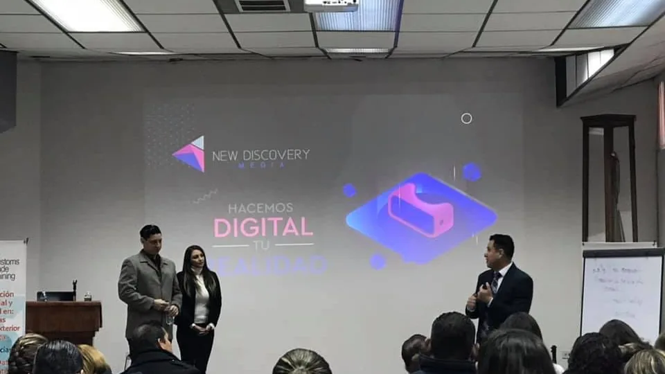 La sala durante la charla, con una diapositiva de New Discovery en pantalla